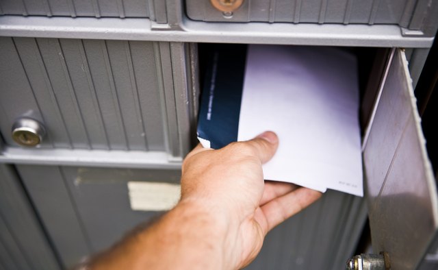Man retrieving mail from communal mailbox