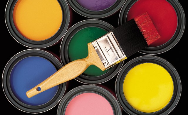 Assorted colors of paint in cans with brush