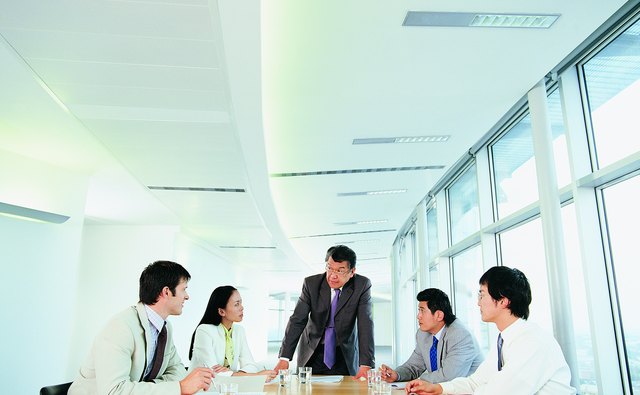 Group of Businesspeople Planning Strategy all Looking at One Man