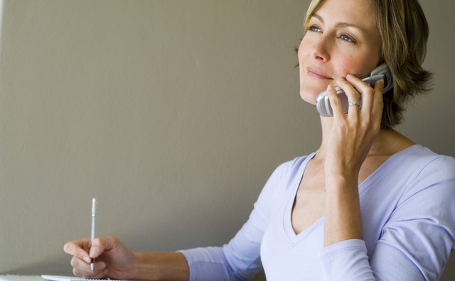 Woman talking on phone and writing