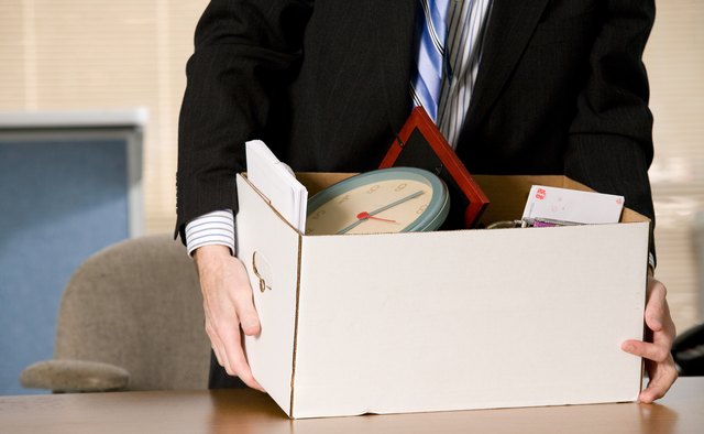 Businessman at desk with box of his belongings