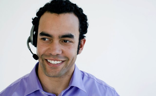 Close-up of businessman wearing headset and talking, studio shot