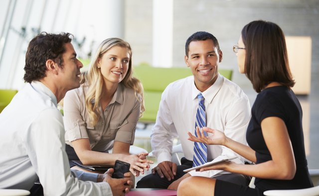 Businesspeople With Digital Tablet Having Meeting In Office