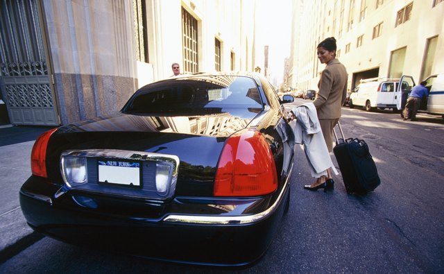 Woman getting into car with luggage