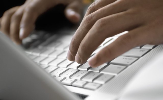 Close-up of a person operating a laptop