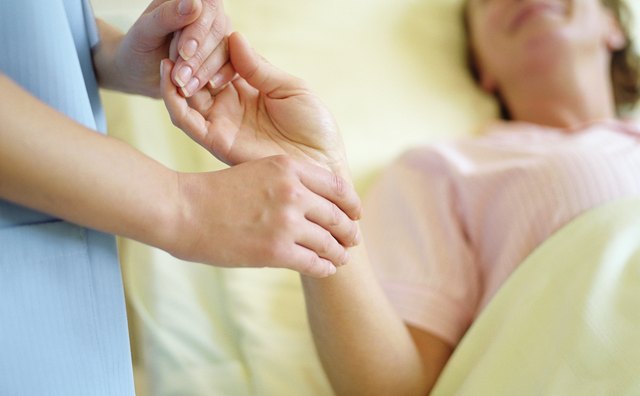 Nurse checking female patient's pulse on wrist, close-up
