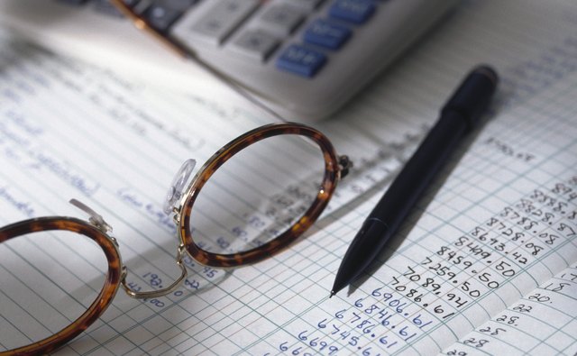 Eyeglasses, pen and ledger