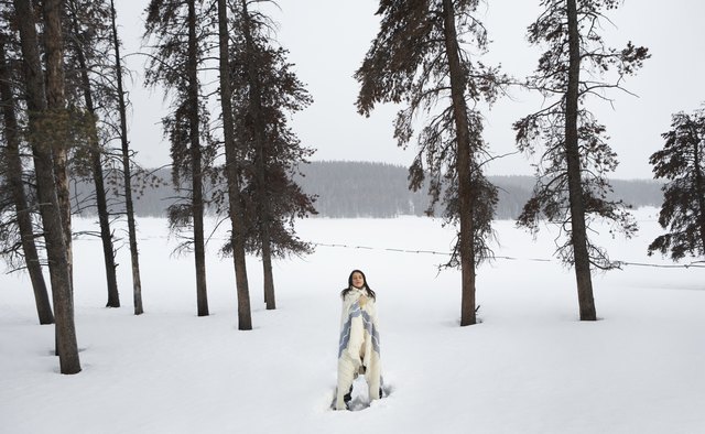Young woman standing in snow, eyes closed