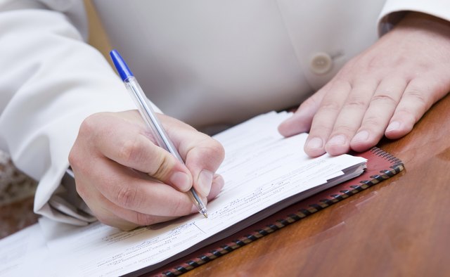 man signing paper