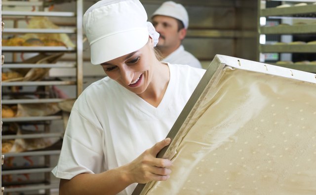 Female baker baking bread rolls