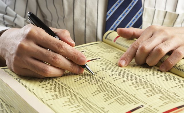 Businessman searching in yellow pages