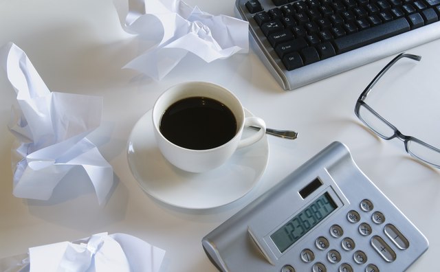 Still life with coffee cup, calculator, and crumpled paper