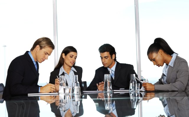 business executives preparing notes while sitting in conference room