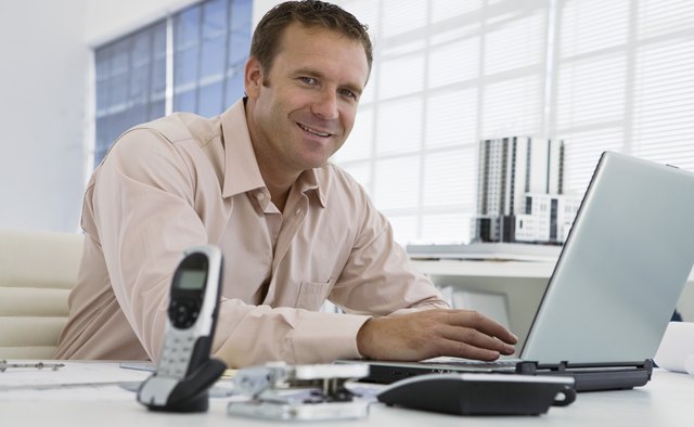 Smiling businessman using laptop