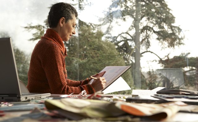 Woman working on pad at desk