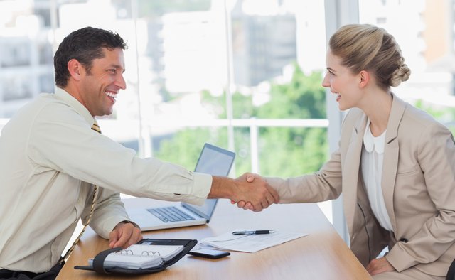 Blonde woman shaking hands while having an interview