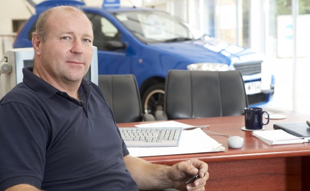 Car salesman sitting in showroom