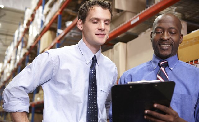 Two Businessmen With Clipboard In Warehouse