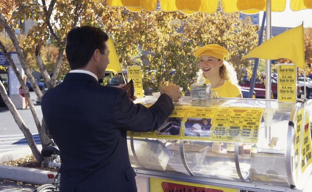 Rear view of a businessman standing at a hot dog vendor