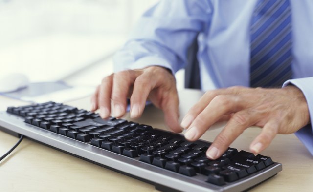 Man using keyboard, close up, mid section