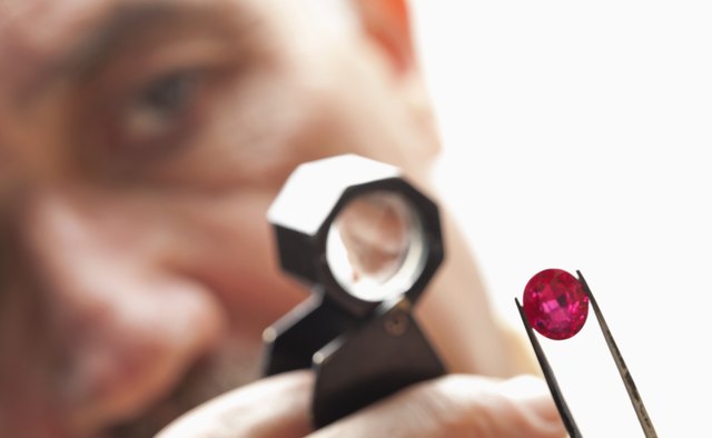 Close up of gemstone with jeweler looking through magnifying glass