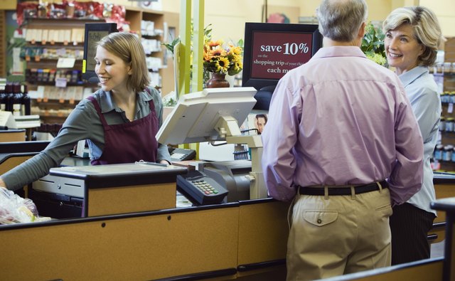 Couple Paying for Items at Supermarket Checkout