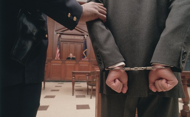Businessman in handcuffs in courtroom