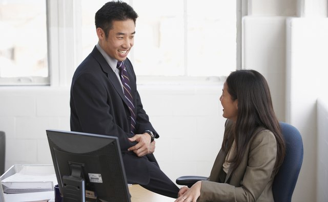 Side profile of businessman and businesswoman smiling in office