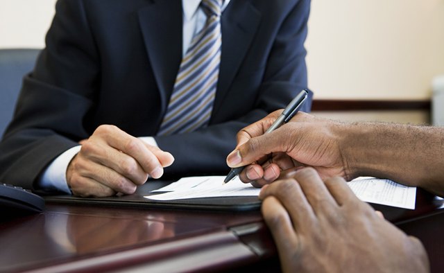 Customer signing paperwork with bank manager