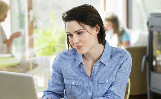 Woman Using Laptop In Cafe