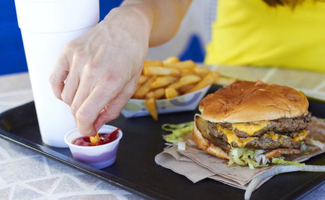 Female Hand Dipping Fries In Tomato Sauce