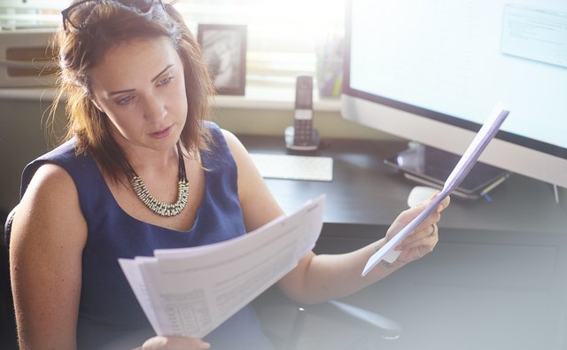 Businesswoman reads through client paperwork