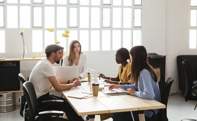 Colleagues working together at desk in office