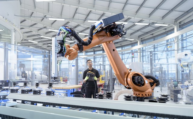 Engineer programming robot in robotics research facility