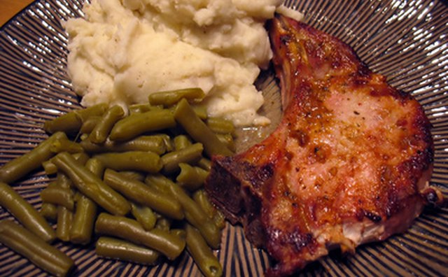 Southern foods: pork chops, mashed potatoes and green beans.