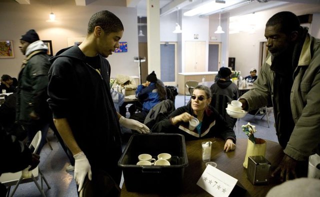 A volunteer collecting dishes at a food pantry.