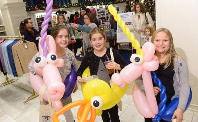 Three girls with balloon animals as part of a fundraiser for St. Jude's children's Research Hospital