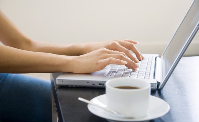 Hands typing on laptop