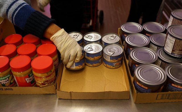 Volunteers stack items at a food pantry.
