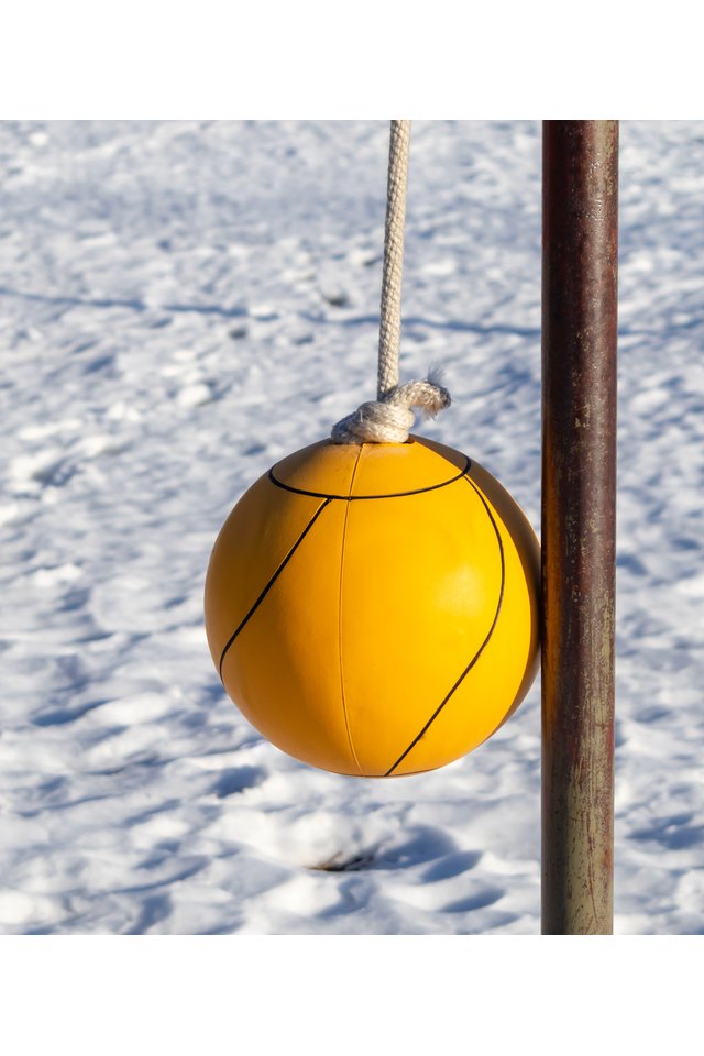 Orange tether ball against a snow ground