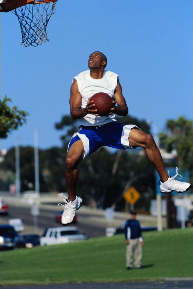 Basketball player shooting basketball in to hoop