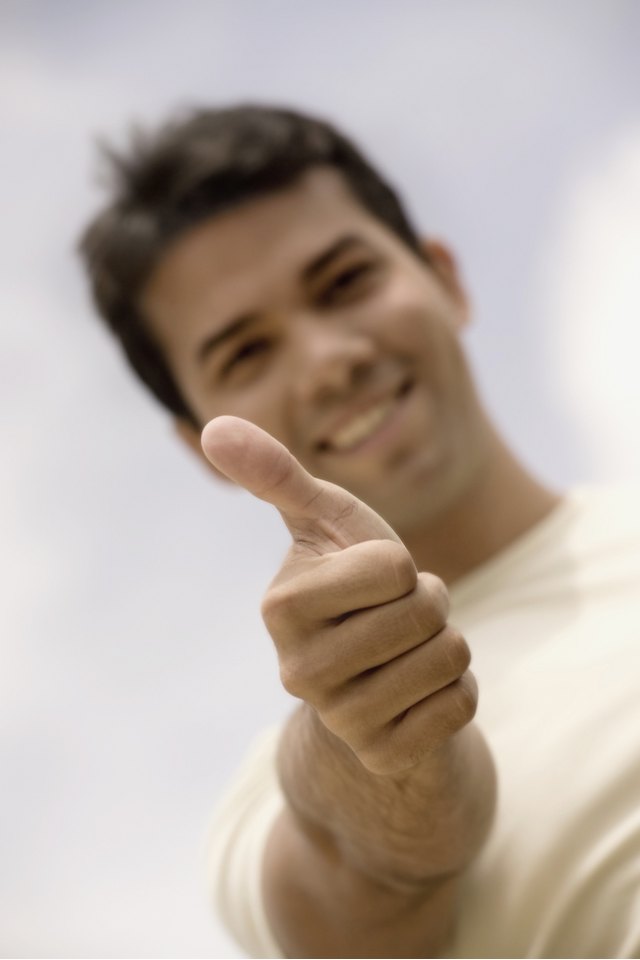 Portrait of a young man showing thumbs up sign