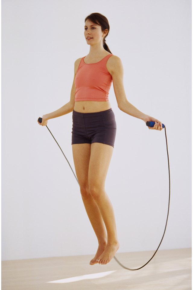 Portrait of a young woman working out with a skipping rope