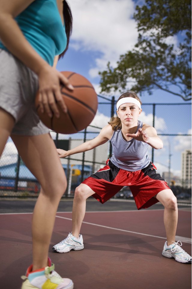 Women playing basketball outdoors