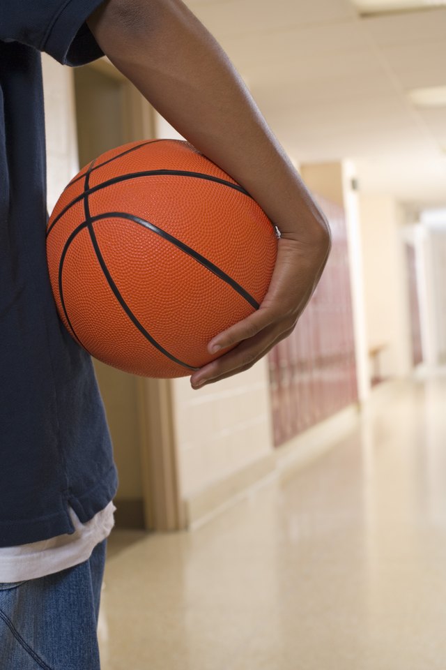 Teen with basketball in hallway