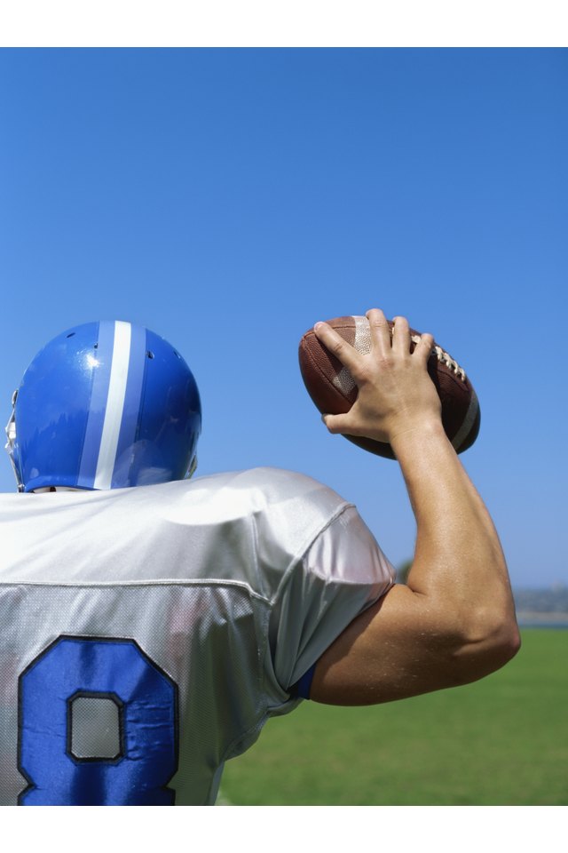 rear view of a football player throwing a football