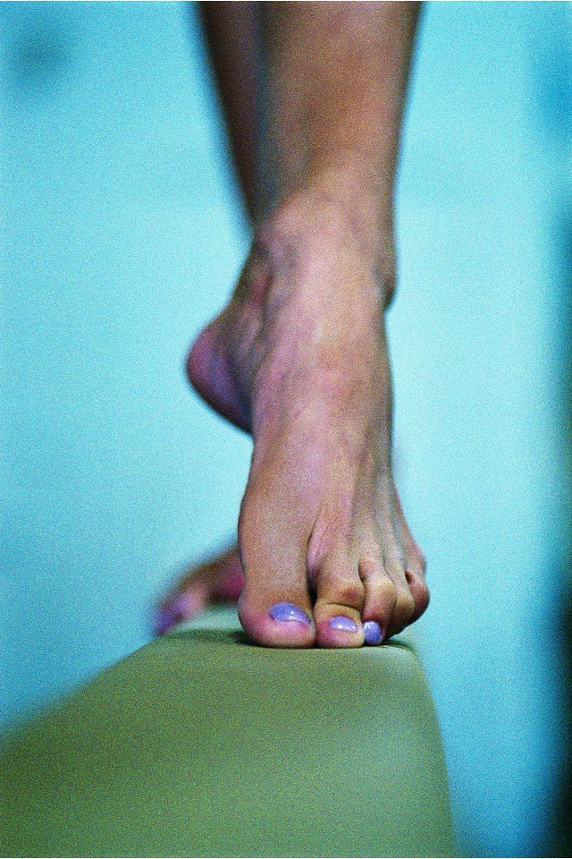 Foot of gymnast on balance beam