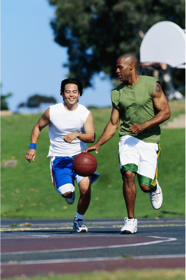 Two young men playing basketball