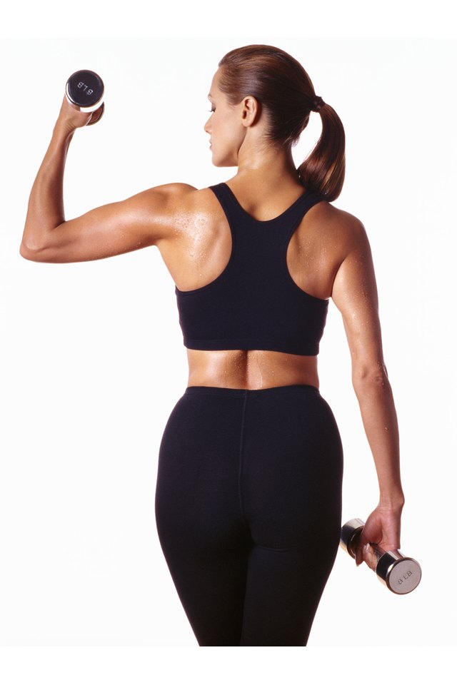 Woman working out with dumbbells, rear view