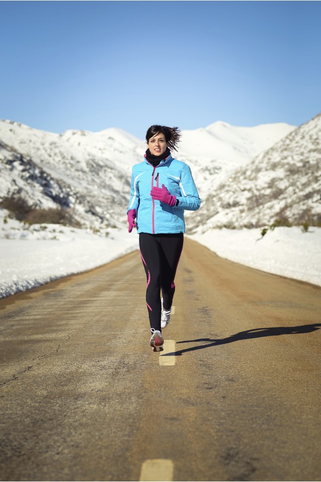 Cold winter woman running in road
